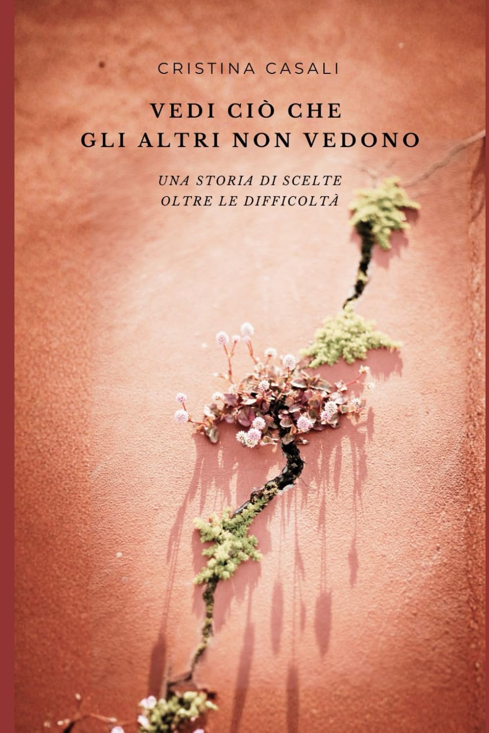Copertina di Vedi ciò che gli altri non vedono di Cristina Casali: piante e fiori crescono da una crepa in un muro color terracotta. Sottotitolo: Una storia di scelte oltre le difficoltà