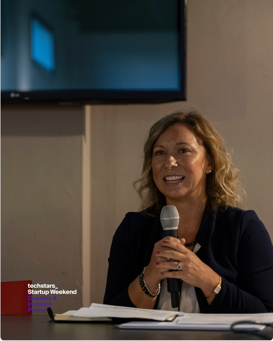 Cristina Casali interviene con un microfono al Techstars Startup Weekend Diversity & Inclusion di Parma.